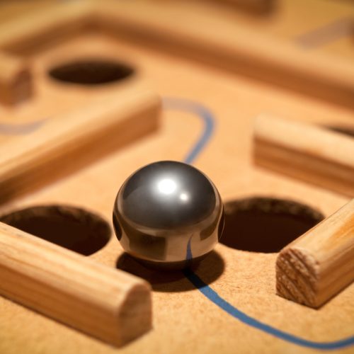 A metal ball carefully balances as it navigates between two obstacles